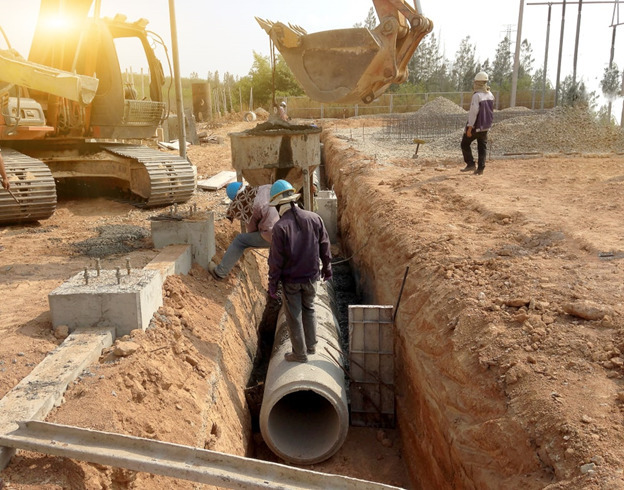 Concrete pipe being installed in a trench before burial - The Use Of Mild Steel Cement Lined MSCL Pipes Malaysia